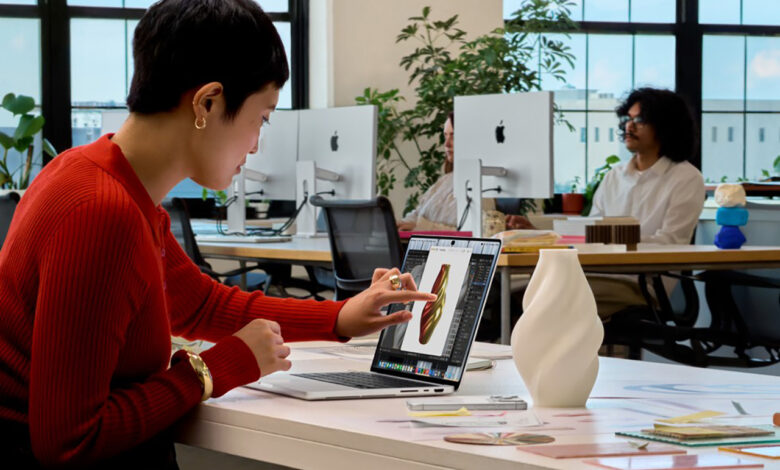 Donna utilizza il touchscreen del nuovo MacBook Pro 2026 di Apple durante un lavoro di progettazione grafica