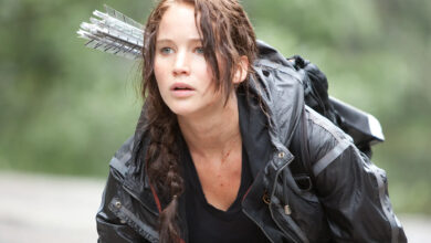 Jennifer Lawrence nei panni di Katniss Everdeen in Hunger Games, con arco e frecce sulla schiena.