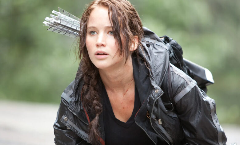 Jennifer Lawrence nei panni di Katniss Everdeen in Hunger Games, con arco e frecce sulla schiena.
