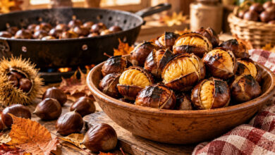 Castagne arrosto appena cotte in una ciotola rustica, con castagne fresche e foglie autunnali